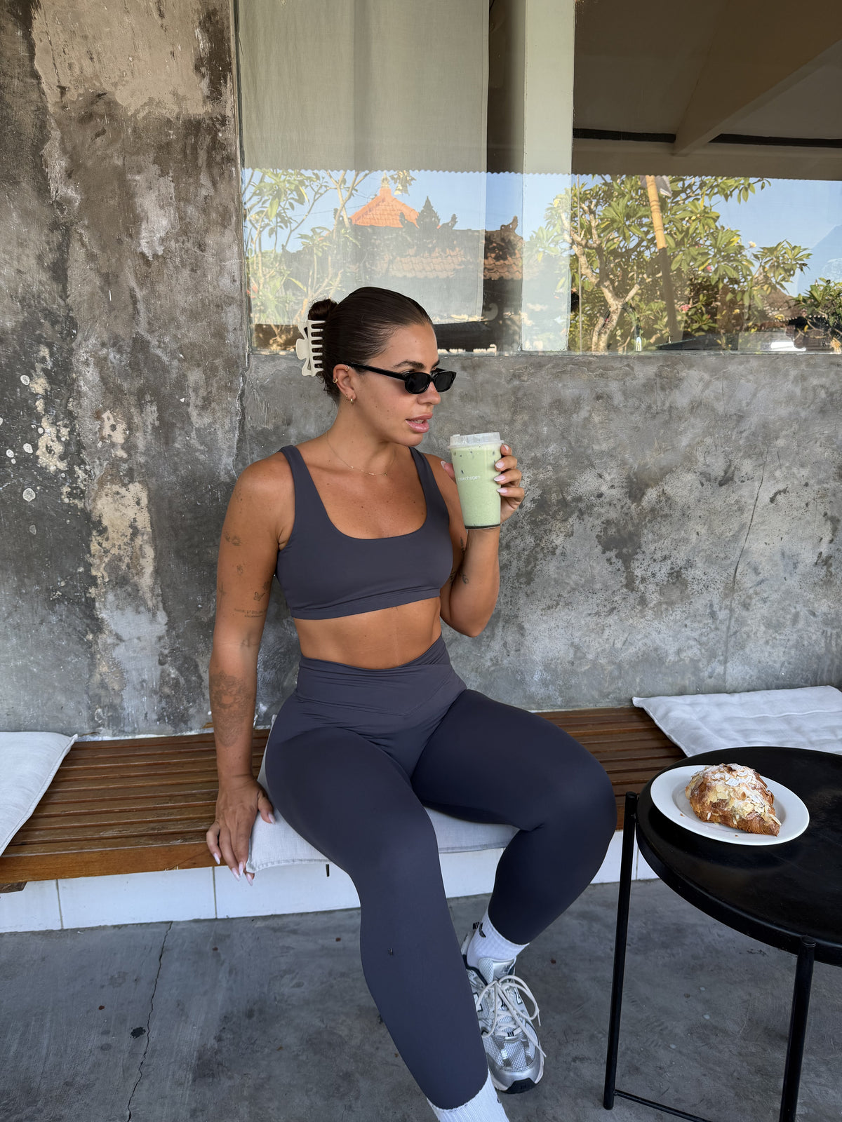 Nova Bralette in Charcoal, seated front view at a café.